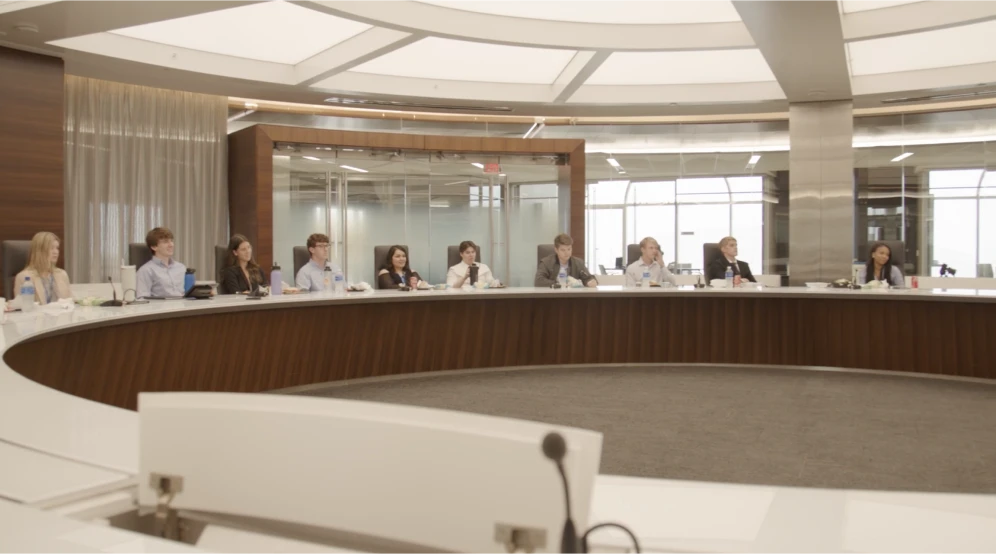 A group of Stifel interns sitting in a large Stifel Conference room, representing our internship programs informational video.