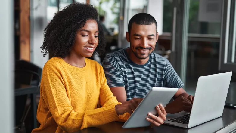 A man and woman looking at information on a tablet.