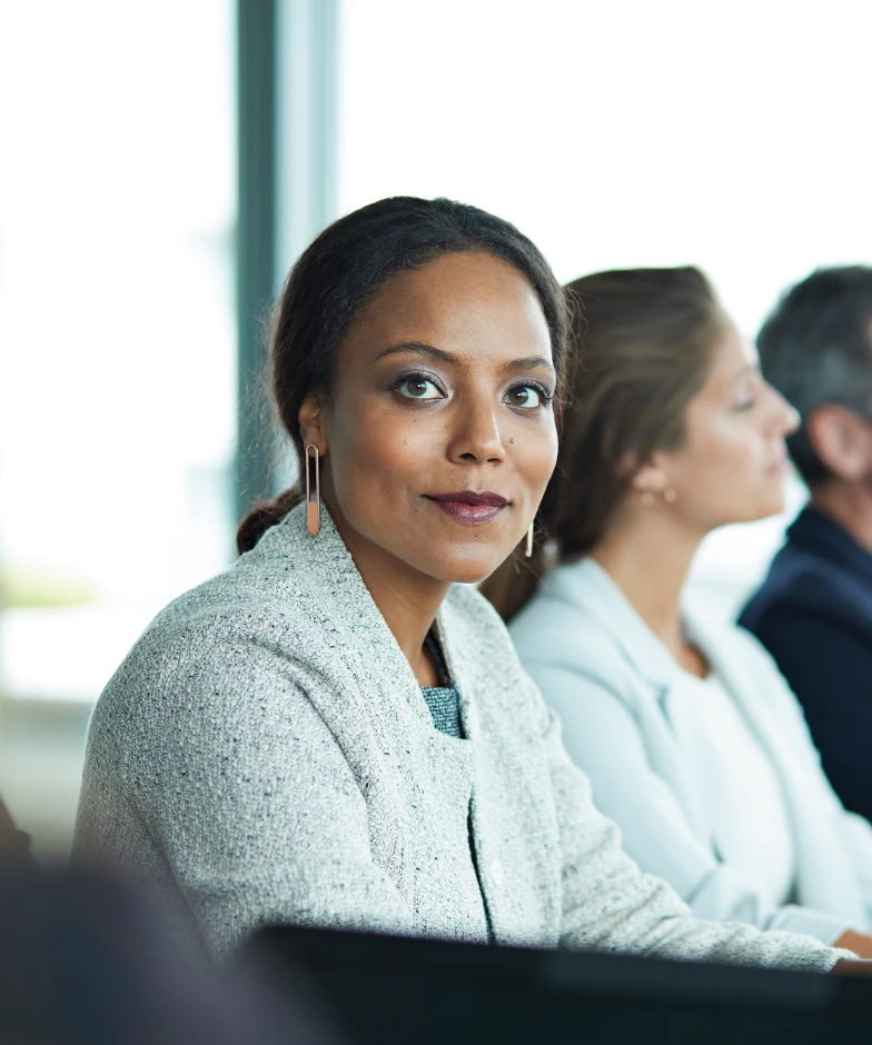 Woman smiling during a meeting. Learn more about Stifel Commercial Lending for Middle Market Companies.