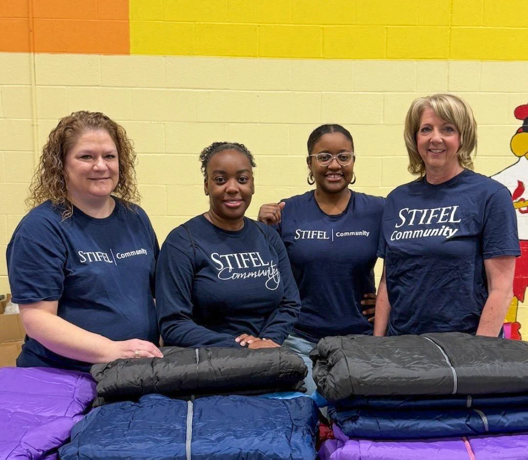 Stifel team members help hand out coats.