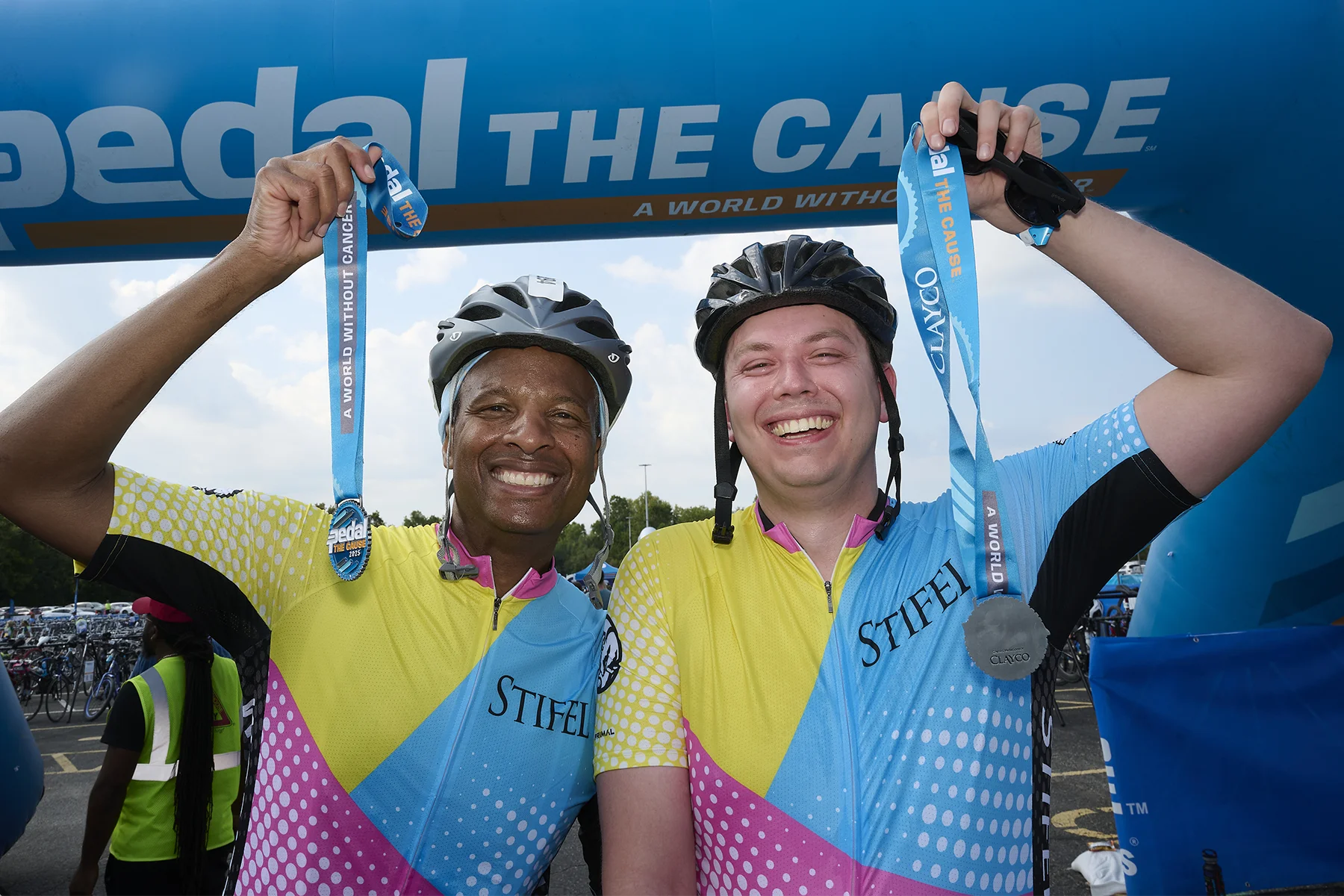 Pedal the Cause riders raise their medals.